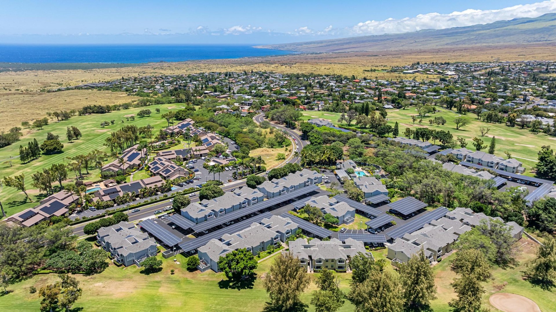 Aerial view of Waikoloa Village resort community with pool, golf course, and ocean